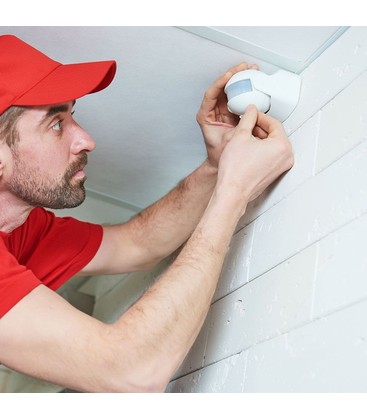 Installation av en vit PIR-rörelsesensor för utomhusbruk som fungerar som master i en krets.