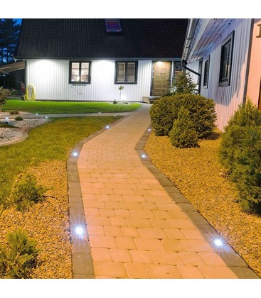 Rund utomhusspotlight i rostfritt stål monterad i en modern utomhusmiljö.